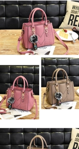 Detail of pink and khaki pebbled leather handbags with furry pompom and V-line stitching