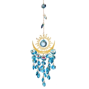 Detail of sun and moon crystal suncatcher with blue water drop pendant and golden frame