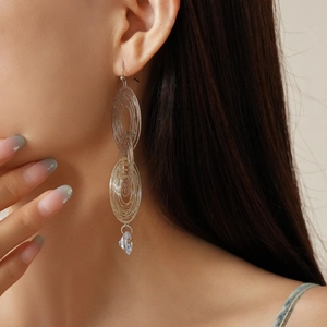Macro detail of silver multi-layer geometric loop earrings with clear zircon stones