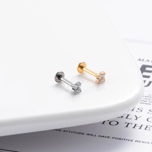 Close-up of G23 titanium push-pin labrets with zircon flower tops in silver and gold