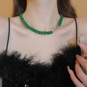 Détail d'un collier en perles de verre géométriques vert émeraude avec fermoir argent