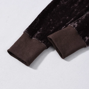 Detail of dark brown velvet sleeve cuff with ribbed texture and embossed fabric finish
