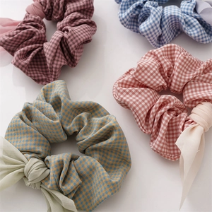 Detail view of four colorful plaid scrunchies with sweet handmade fabric bows