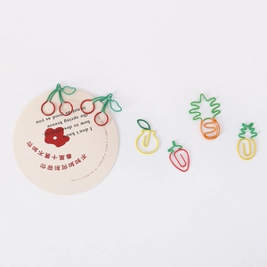 Creative fruit shaped metal paper clips including cherry and strawberry on white background