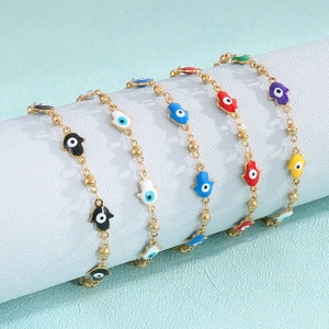 Gold-plated stainless steel bracelet featuring colorful evil eye and Hamsa palm charms