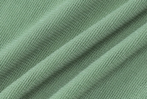Detailed macro view of bean green waffle knit fabric with silver glitter threads