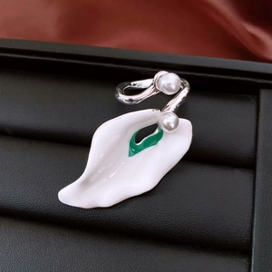 Detailed shot of enamel flower petal ring with green center and twin pearl accents