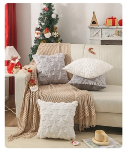 Dettaglio del copricuscino natalizio con trama 3D ad albero geometrico su divano beige