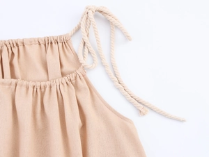 Détail de la bandoulière en corde et de l'encolure plissée sur la robe longue en lin