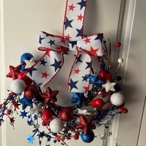 Independence Day wreath with red, white, and blue stars, glitter balls and ribbon on door