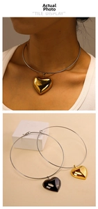 Detailed macro view of large heart pendants in polished gold and black finishes