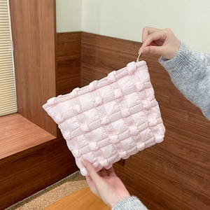 Detail of pink bubble texture cosmetic bag showing gold zipper and compact hand-held size