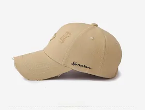 Detailed side view of khaki distressed baseball cap with Narason embroidery and torn details