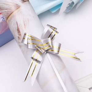 Macro detail of silver pull bow with gold stripes on marble paper gift wrapping
