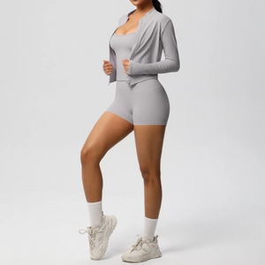 Detailed close-up of light gray three-piece yoga set with jacket, sports bra and shorts