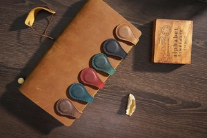 Detail of six colorful handmade crazy horse leather magnetic bookmarks on wood