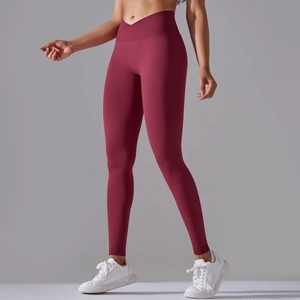 Close-up of seamless yoga leggings featuring a V-shaped cross high waistband in deep red