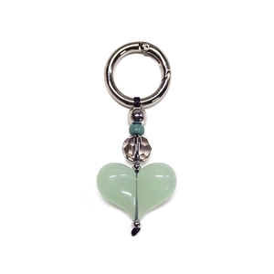 Close-up of heart-shaped green bead keychain with silver ring clasp and faceted beads