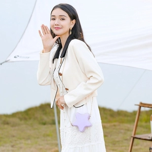 Star-shaped light purple PVC jelly bag with thin metal chain strap on grass background