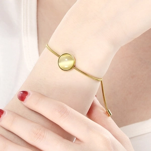 Bracelet chaîne serpent dorée avec pierre œil de chat jaune et fermoir à boule réglable