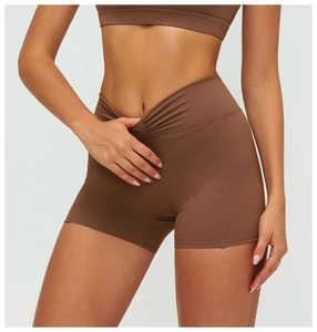 Close-up of high-waist crossover V-belt and ruched detail on brown yoga shorts