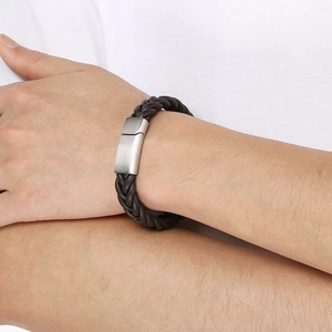 Detail of dark brown braided leather bracelet with silver magnetic clasp on man wrist