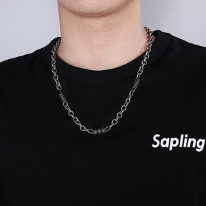 Close-up of industrial style dark metal O-chain necklace with cylindrical links on model