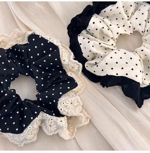 Detail of vintage polka dot hair scrunchies with elegant lace trim in black and beige colors