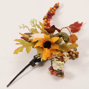 Close-up of artificial autumn branch with sunflower, maple leaves and red berries