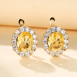 Detail of champagne gold lever-back earrings with oval yellow gem and halo pave crystals