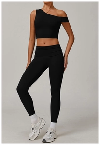 Détail d'une brassière de sport asymétrique noire et d'un legging de yoga assorti