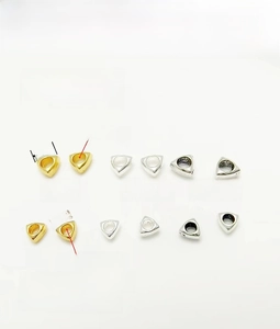 Detailed view of triangle spacers in gold and silver for DIY jewelry making