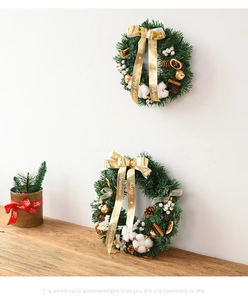 Detailed view of Christmas wreath with pine cones, cotton balls and Merry Christmas ribbon