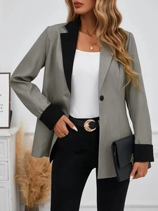 Détail d'un blazer gris avec revers et manches contrastés noirs et boucle de taille en métal