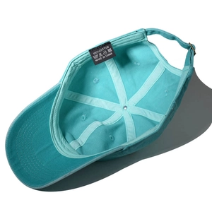 Detail view of cotton baseball cap interior with 100% cotton label and metal buckle
