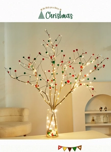 Christmas dry branch decor with red green and white pom poms in a glass vase