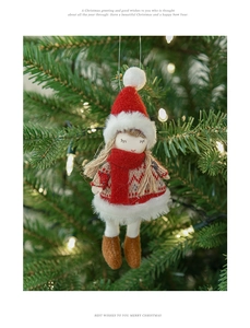 Primo piano dell'angelo di Natale in maglia appeso all'albero con luci festive sfocate