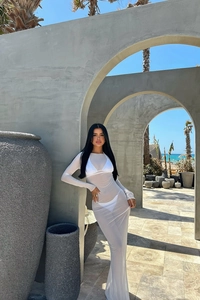 Détail d'une robe en résille blanche transparente portée sur un bikini à la plage