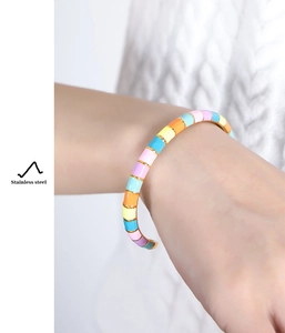 Detail of a stainless steel open cuff bracelet with colorful macaron enamel blocks