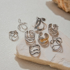 Detail of luxury gold and silver titanium steel rings on a natural stone display