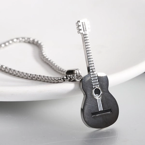 Hip hop stainless steel guitar pendant necklace displayed on a white ceramic plate
