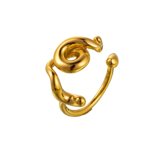 Close-up of golden stainless steel ring with elegant twisted swirl and open design