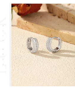 Vue macro de boucles d'oreilles créoles en argent S925 sur pierre et roses séchées