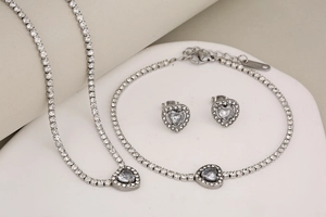Macro view of silver stainless steel tennis jewelry set with heart crystal charms
