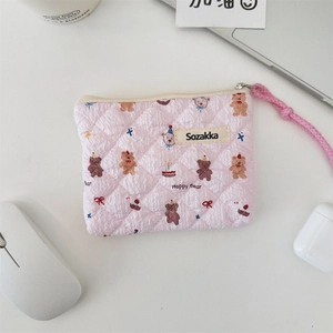 Detailed close-up of pink quilted cotton makeup bag with cute bear and floral patterns