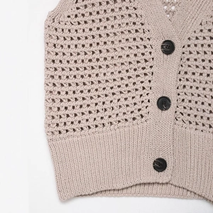 Retro beige knit vest featuring intricate hollow crochet patterns and marble texture buttons