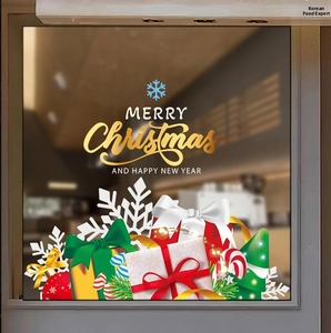Detail of golden Merry Christmas window stickers with gift boxes and snowflakes