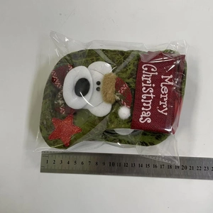 Detail of green faux leather Christmas stocking featuring a 3D plush bear and red star