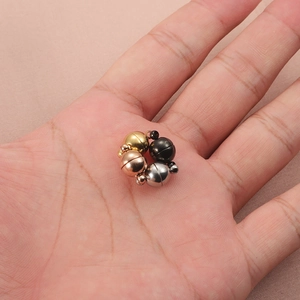 8mm magnetic ball clasps in gold silver and rose gold held in hand for scale