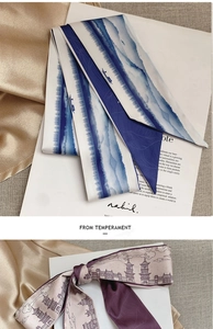 Detail of elegant skinny silk scarves with blue mountain ink and red tower prints